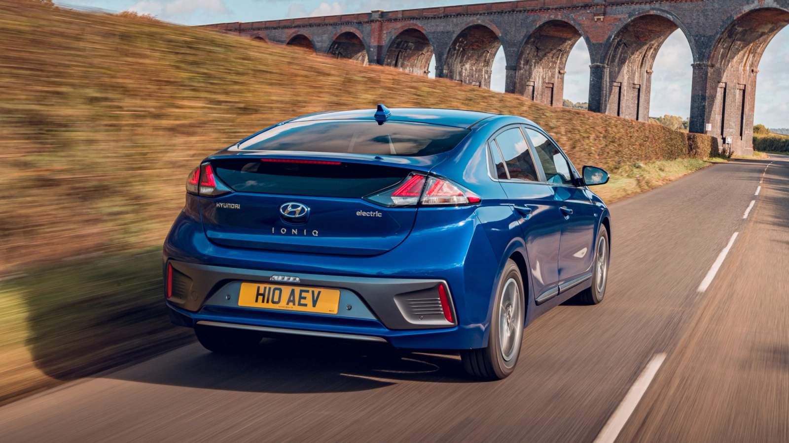 Blue Hyundai Ioniq Electric driving towards a viaduct