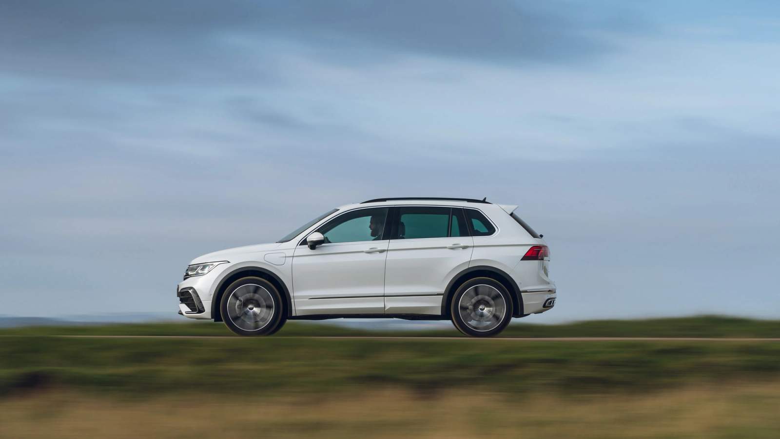 White Volkswagen Tiguan side driving