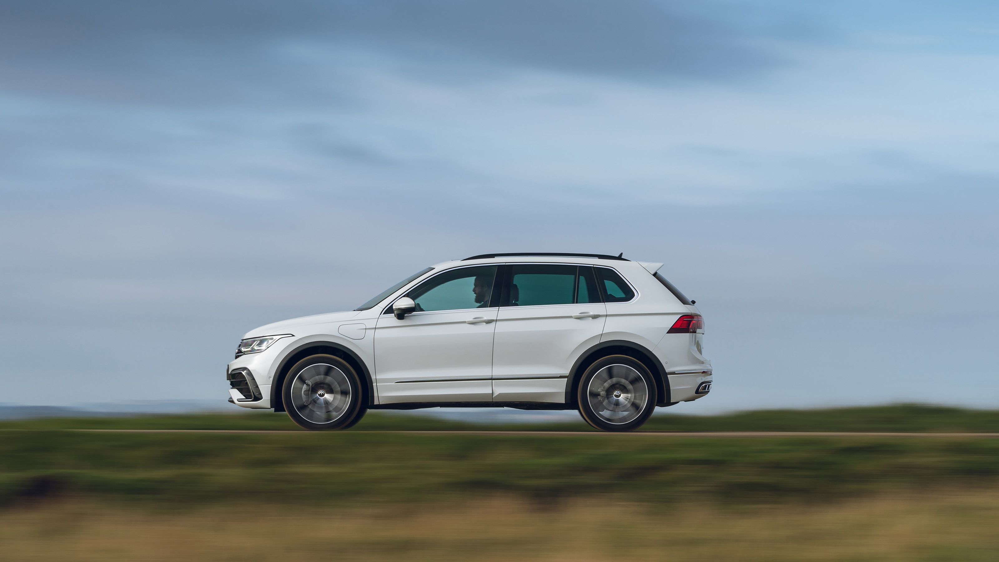 White Volkswagen Tiguan side driving