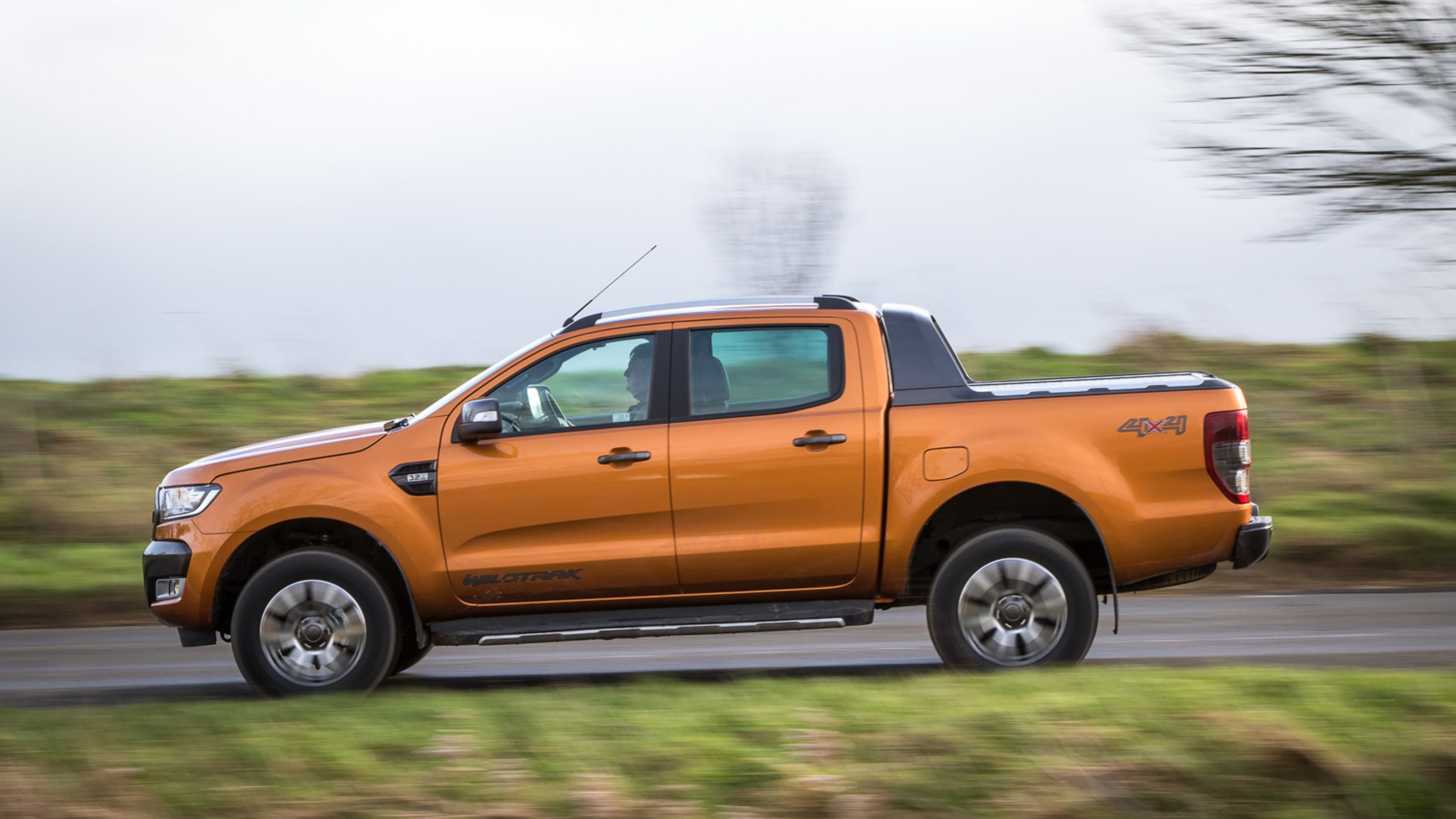 Orange Ford Ranger side driving