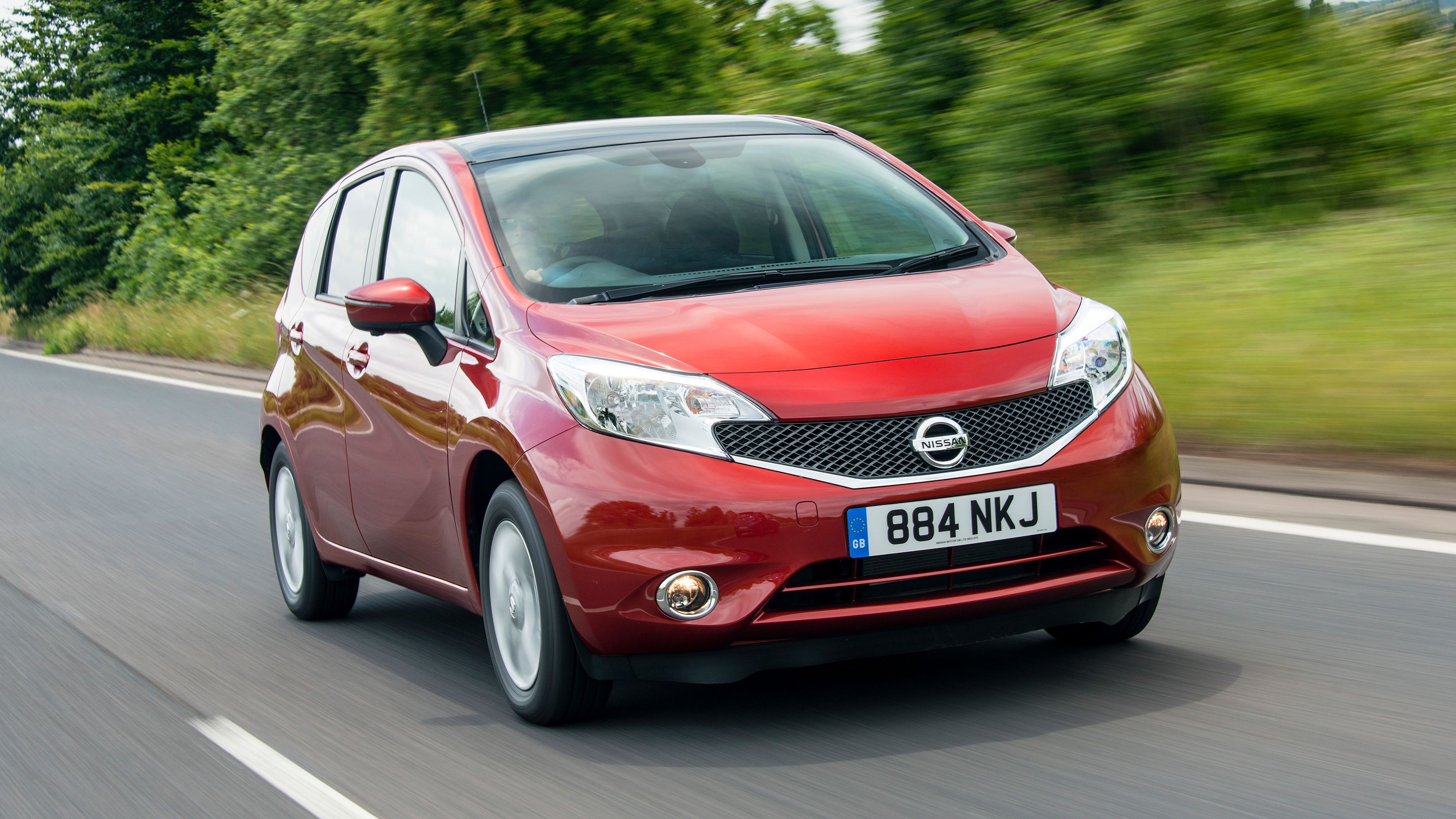 Red Nissan Note front driving