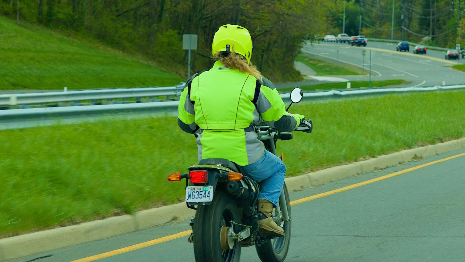 Lady riding motorbike with hi-vis on
