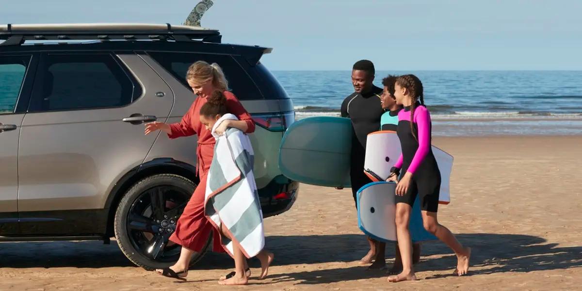family near car at the beach
