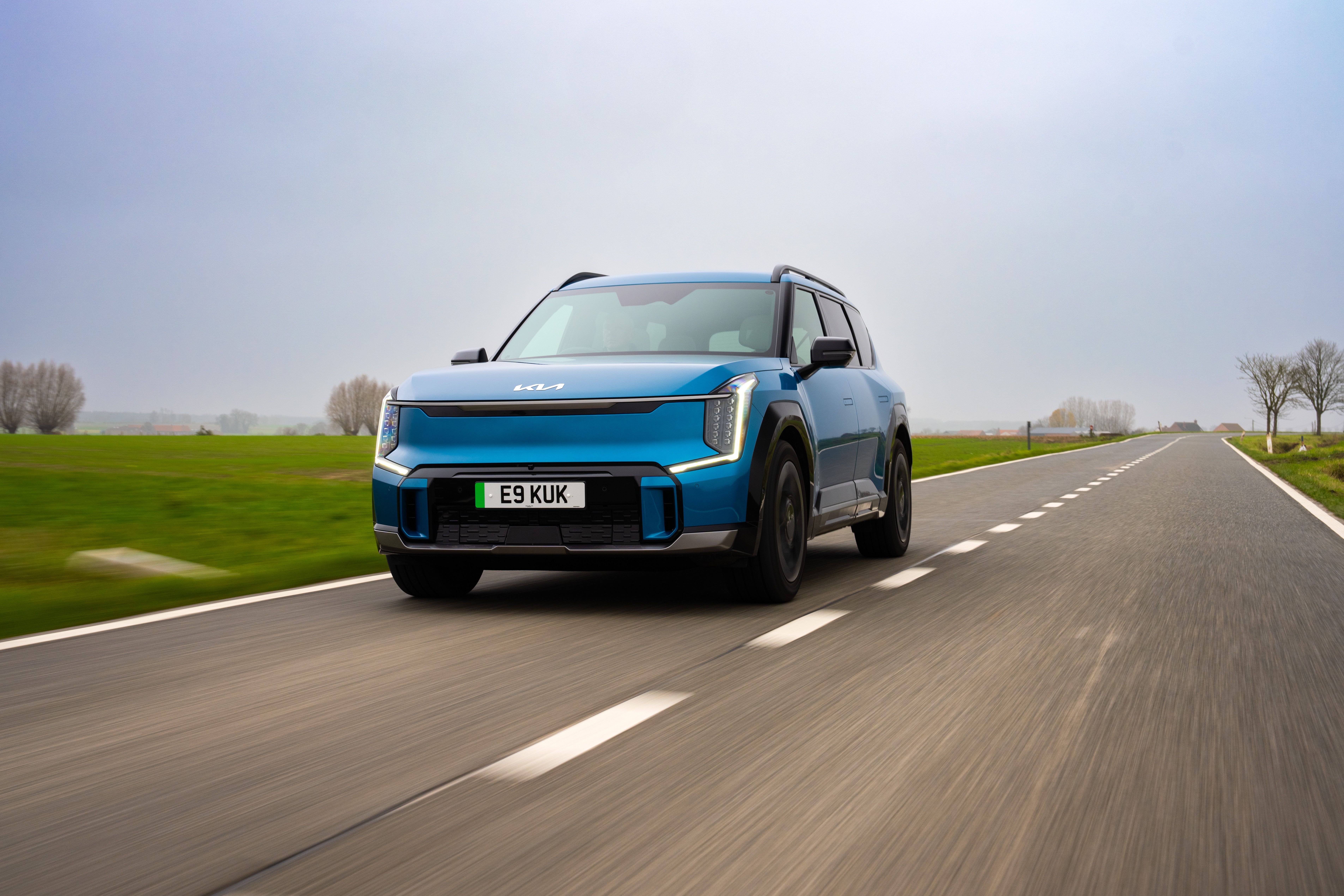Blue Kia EV9 driving
