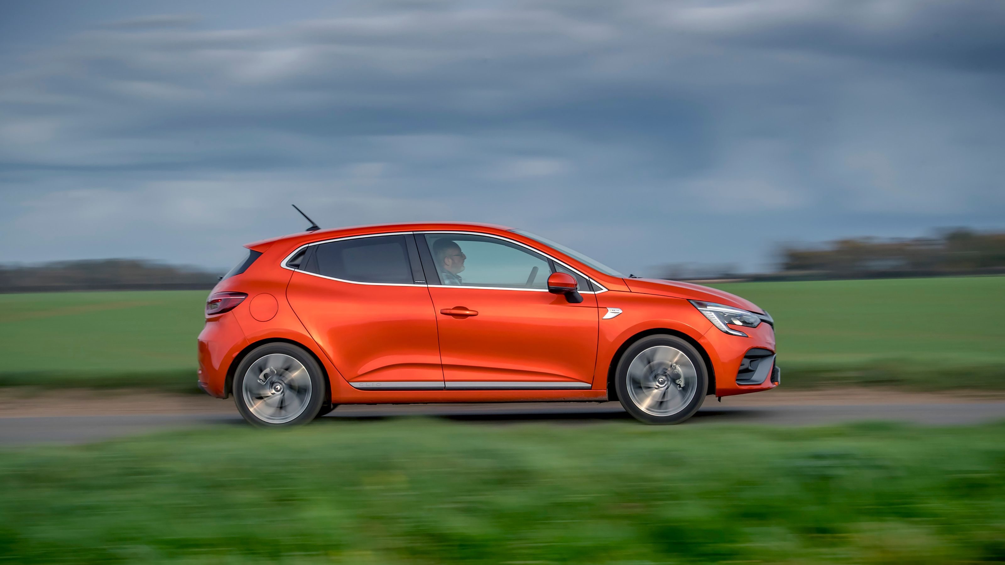 Orange Renault Clio side driving