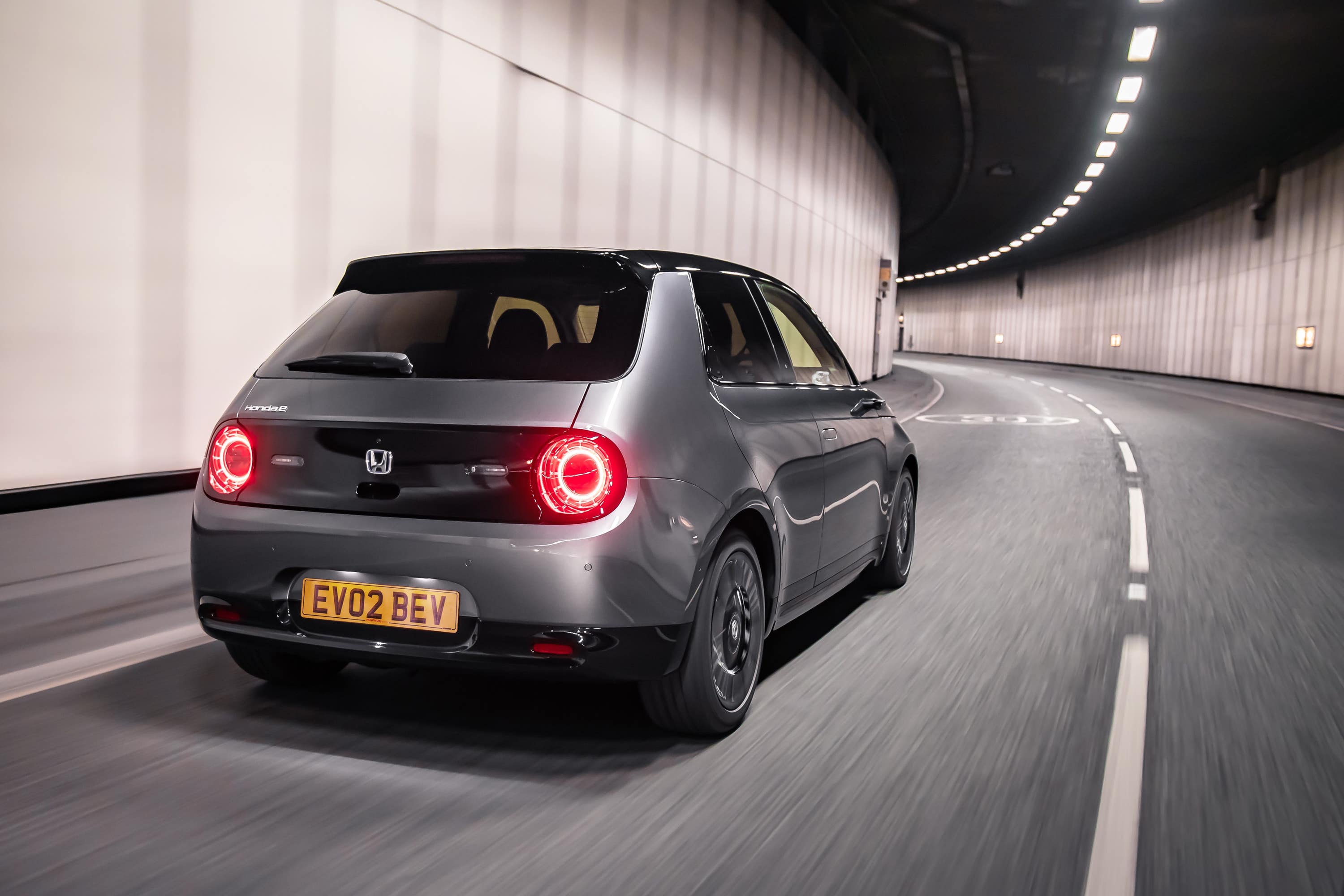 Grey Honda E rear driving