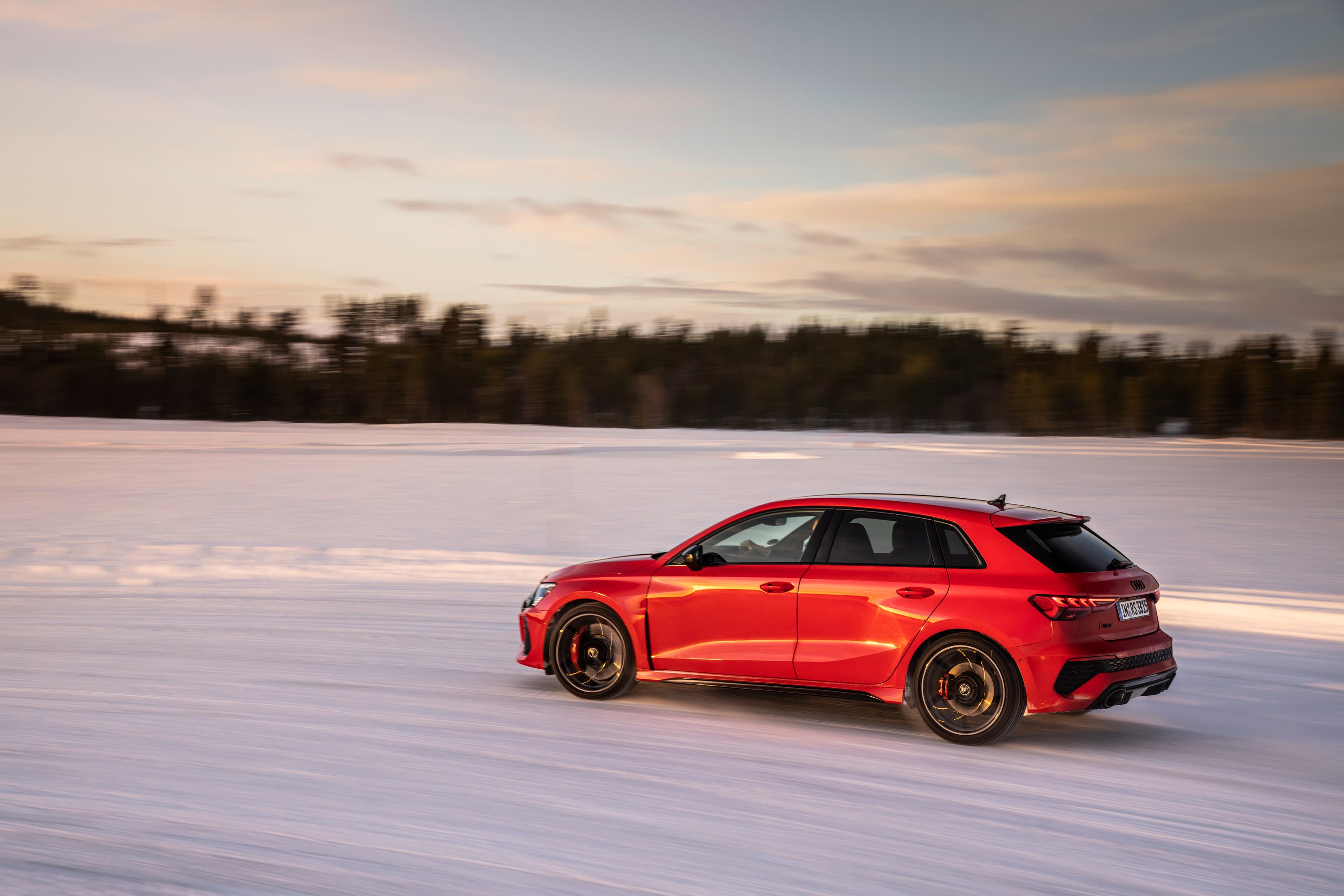 Red Audi RS3 driving on snow