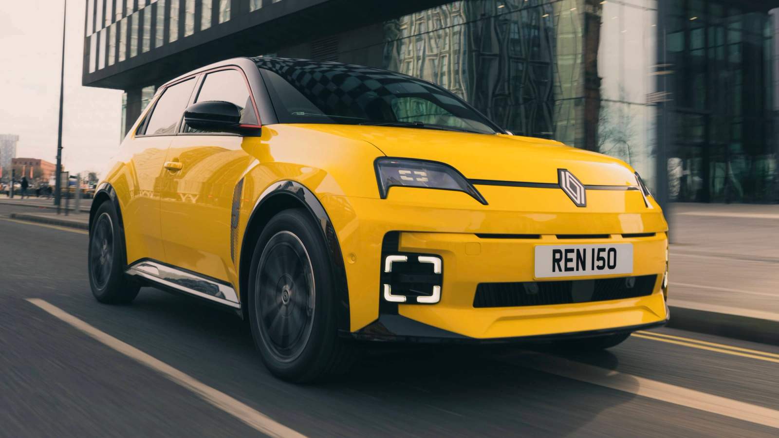Yellow Renault 5 E-Tech driving through the city