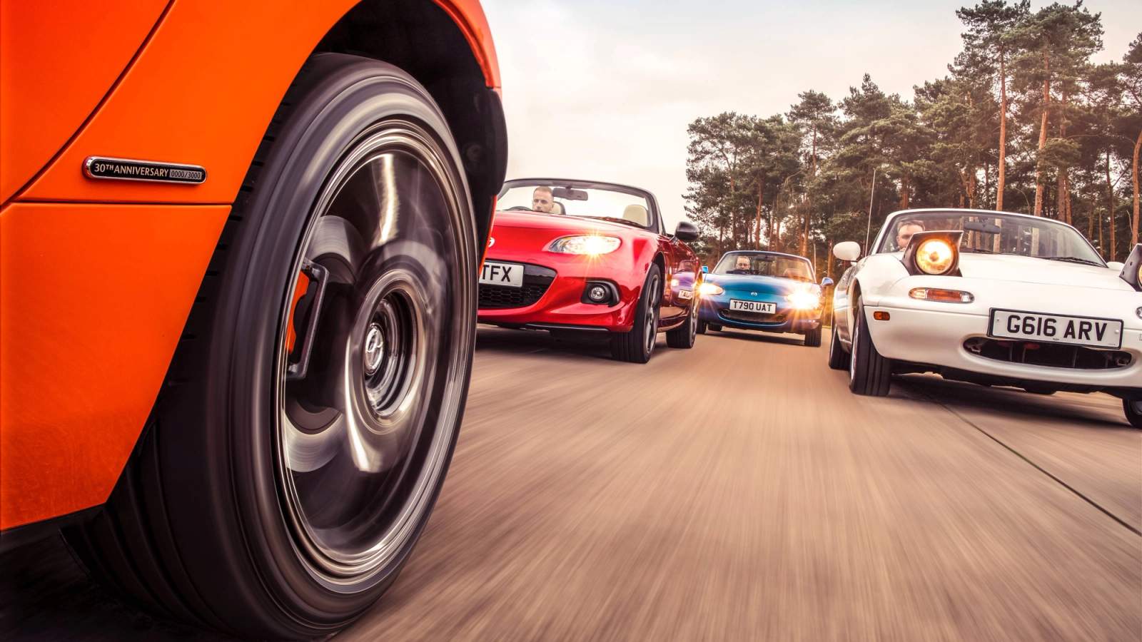 Different generations of Mazda MX-5 on track