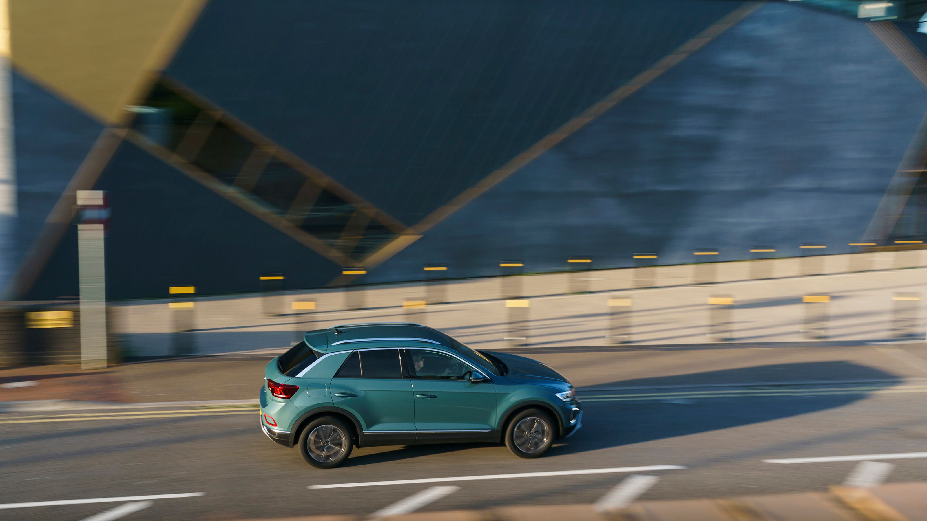 Blue Volkswagen T-Roc side driving