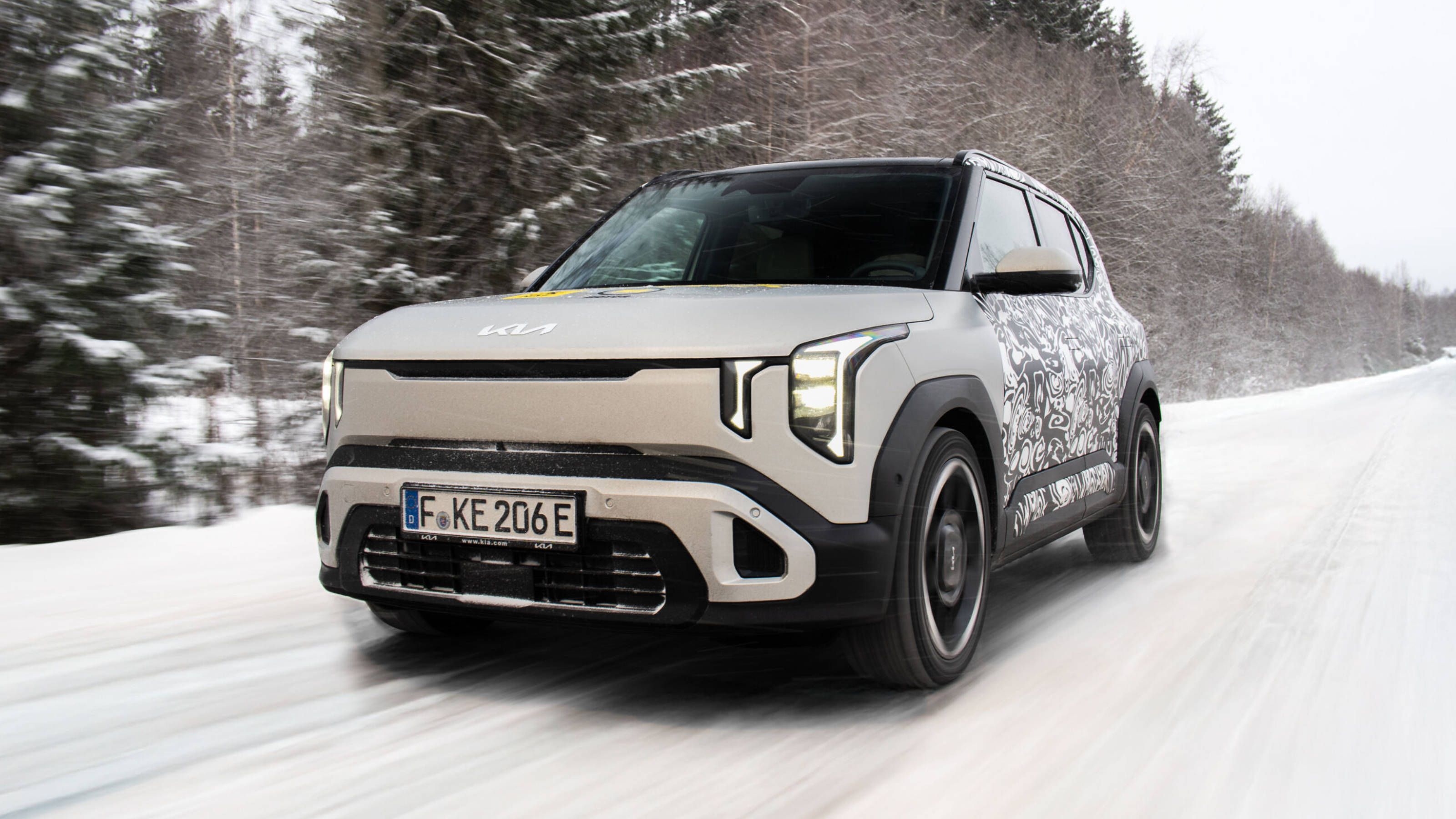 White Kia EV2 driving in the snow
