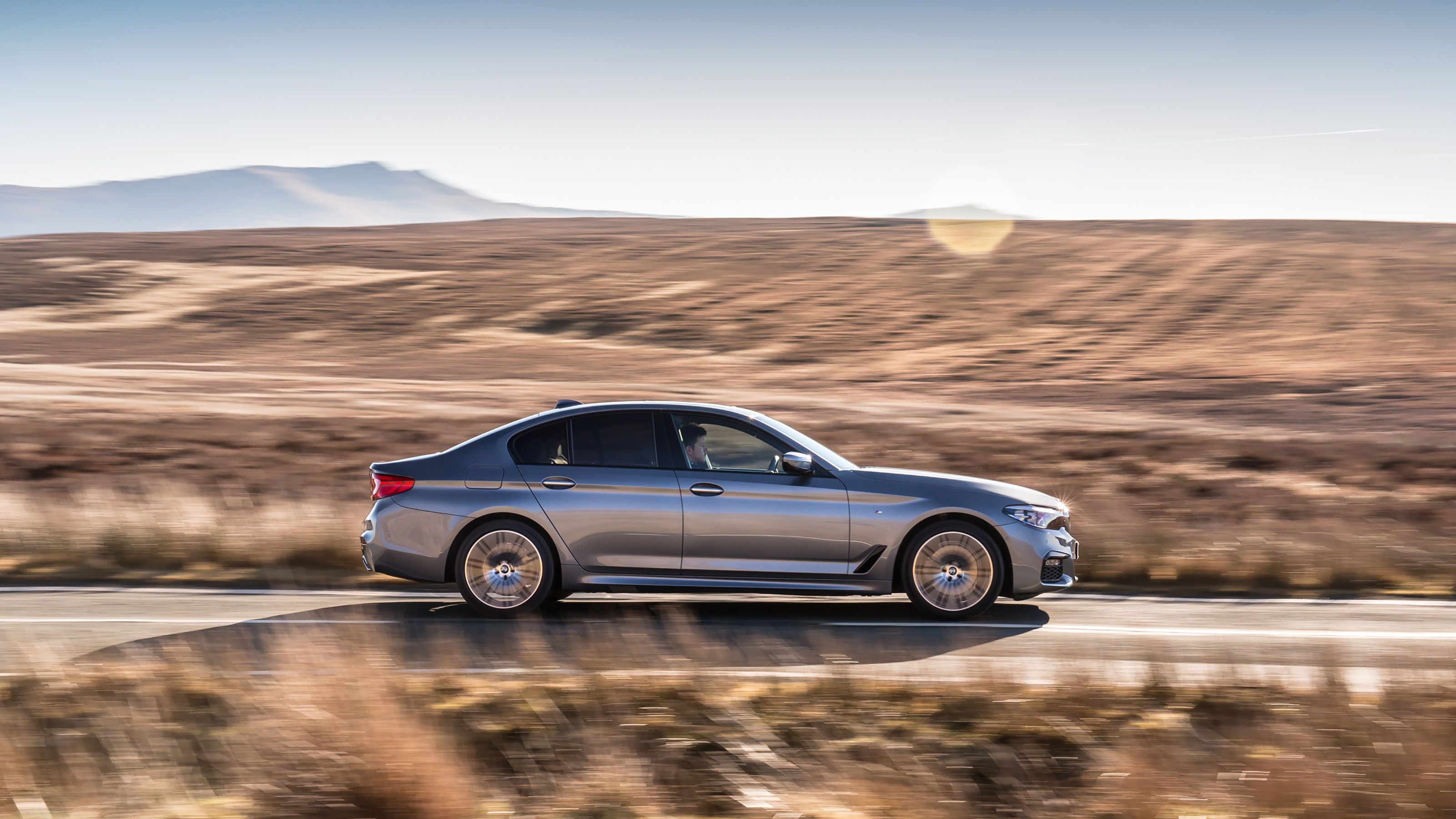 Grey BMW 5 Series side driving