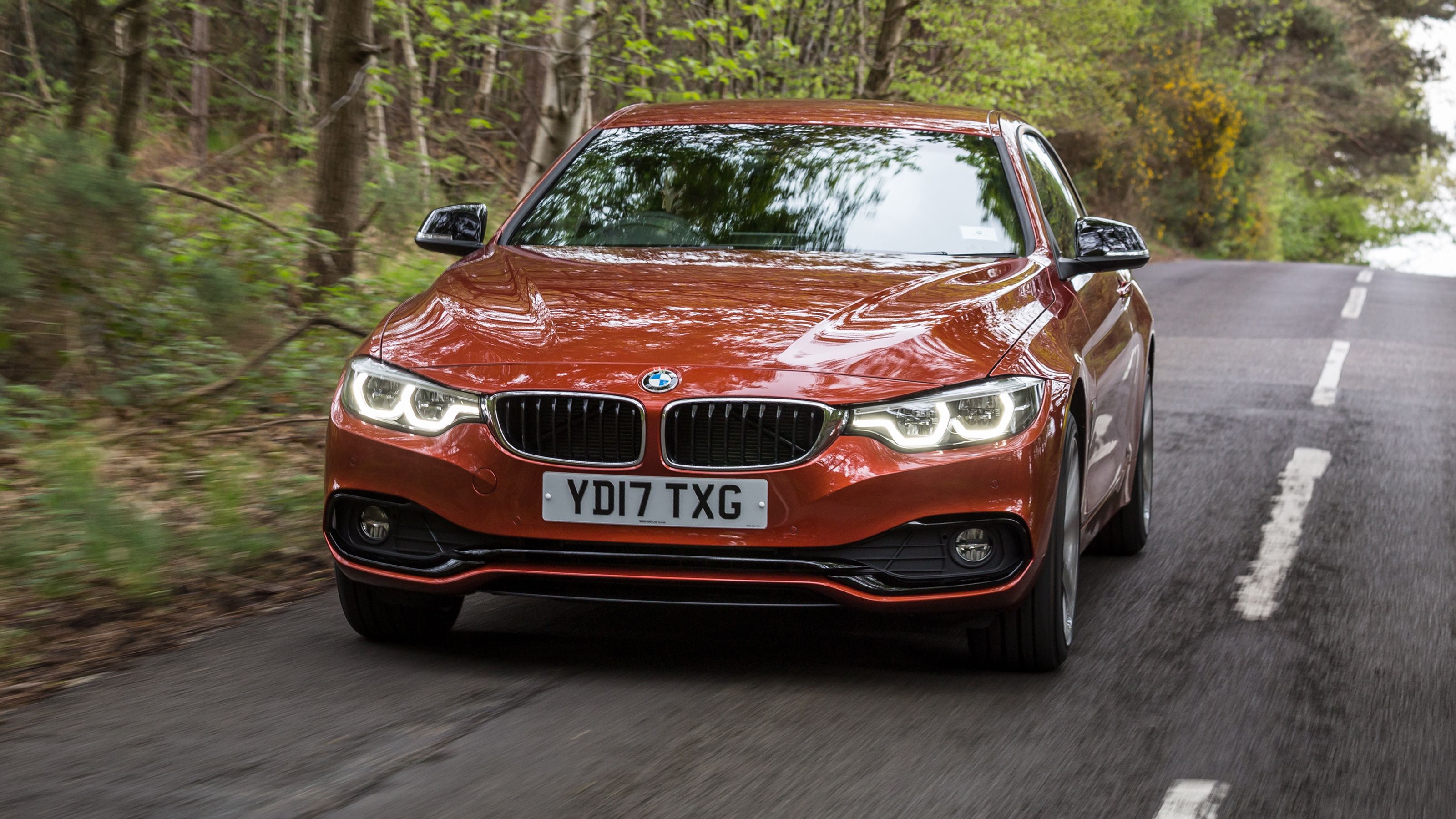 Orange BMW 4 Series front driving