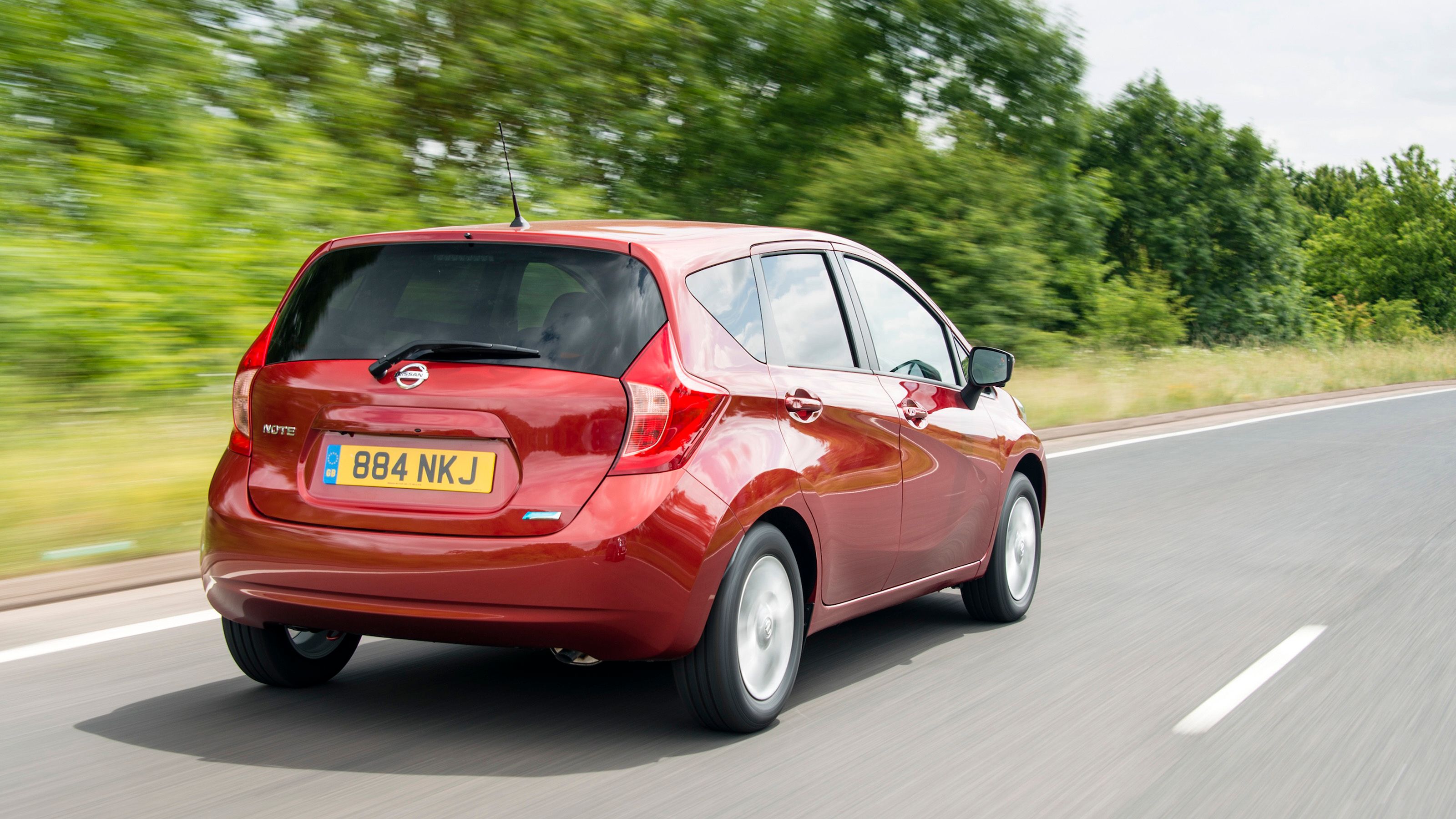 Red Nissan Note rear driving
