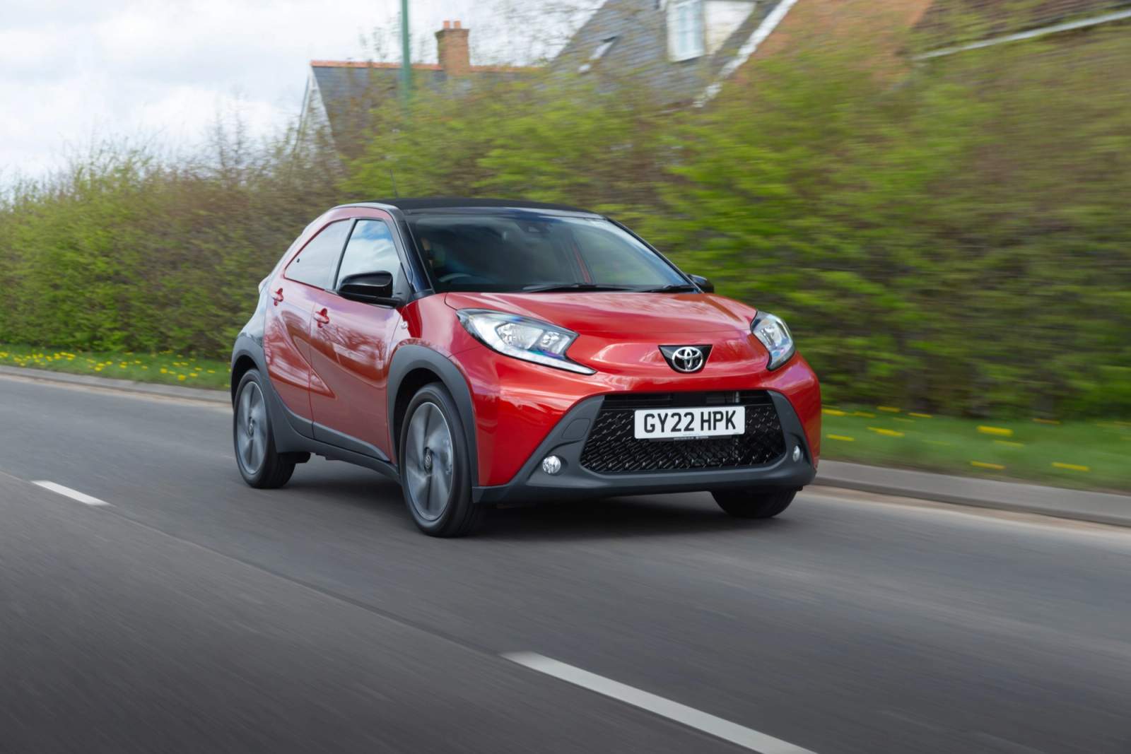 Red Toyota Aygo X driving
