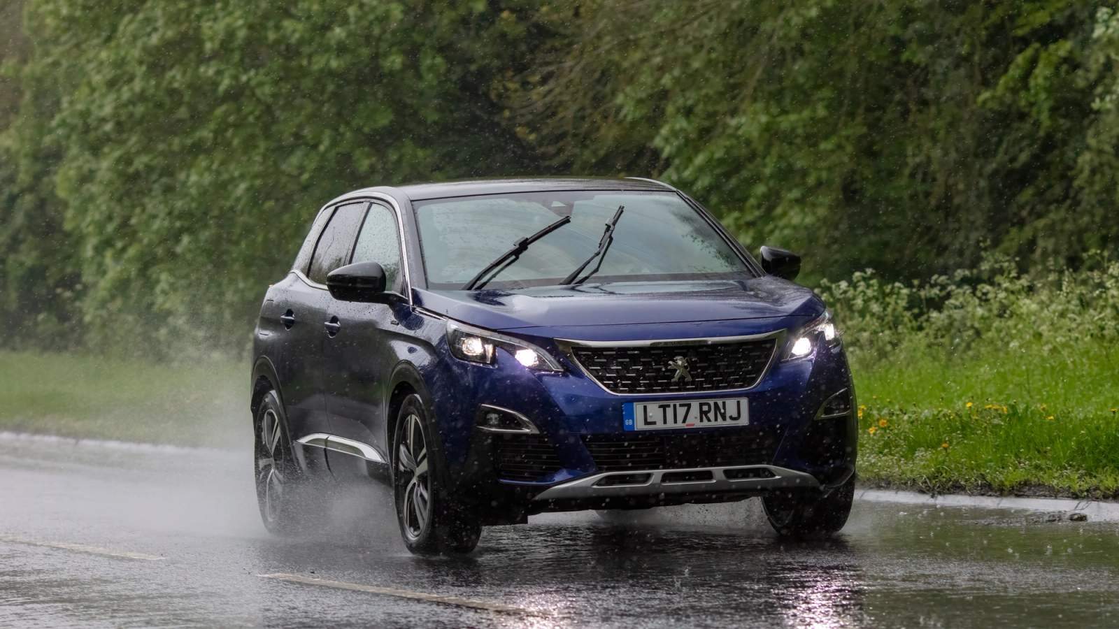 Blue car on the road in the rain