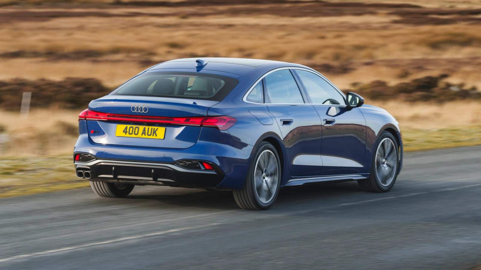 Blue 2025 Audi A5 driving on a country road