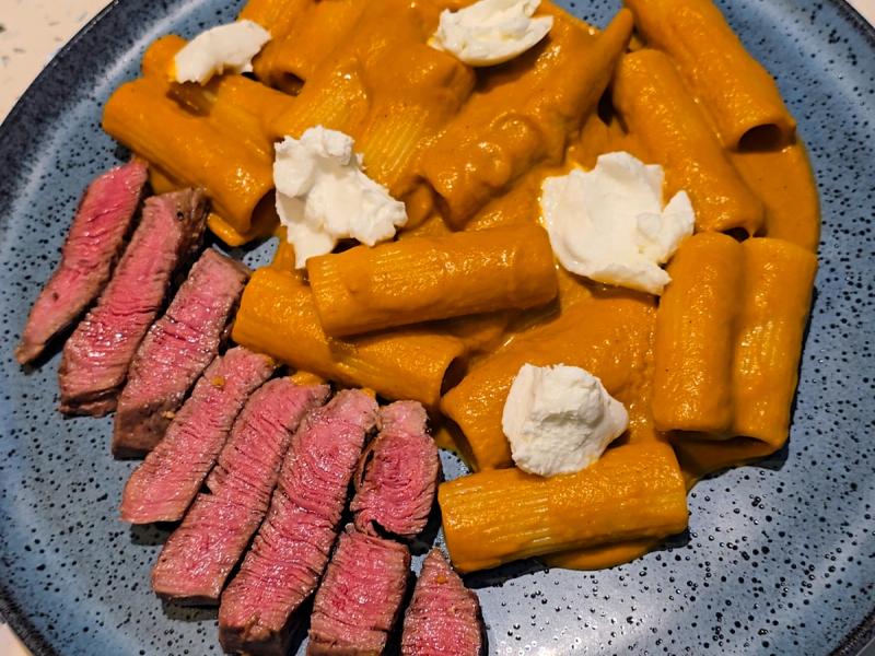 Pasta com tomates assados e burrata, acompanhado de filé mignon.