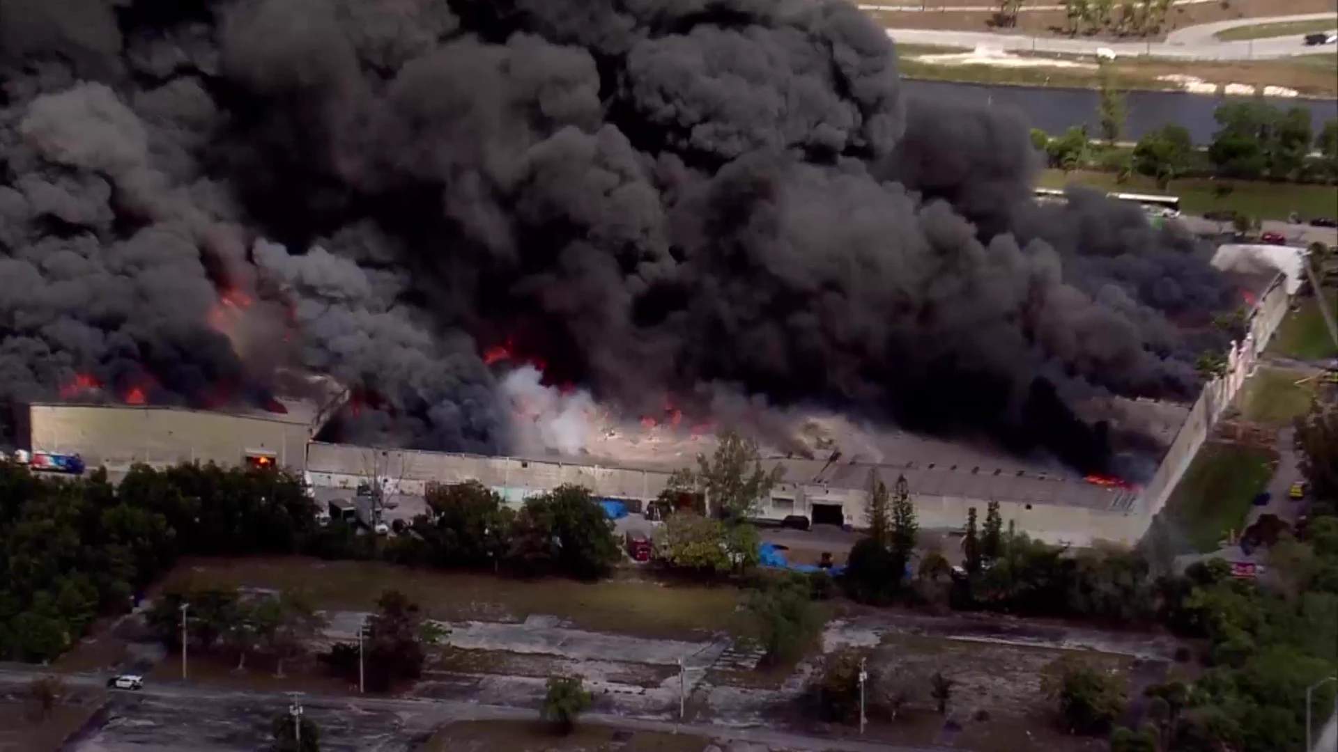Massive warehouse fire sends thick black smoke into the sky as Miami-Dade Fire Rescue units battle the five-alam blaze at Global Warehouse Solutions.