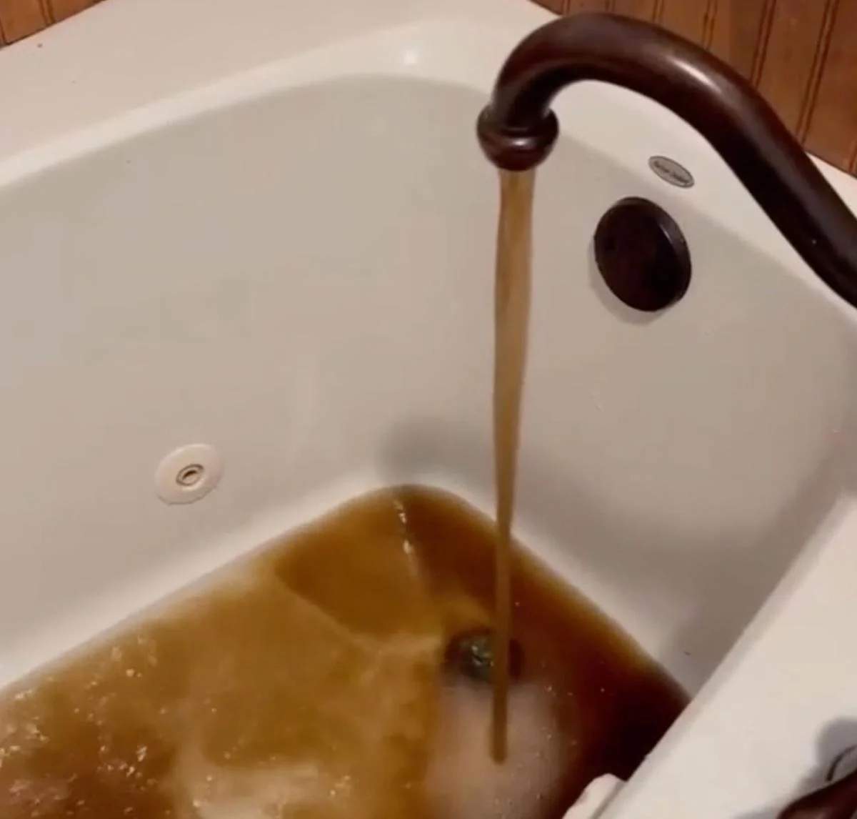 Bathtub filling with brown muddy water from faucet in Trinidad Texas