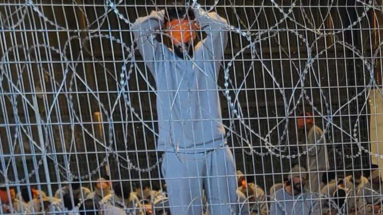 A prison stands blind folded against a razor wire fence in Sde Teiman