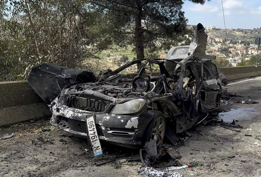 A journalist carries burned safety gear from a car that was hit by an Israeli airstrike, which killed three journalists in south Lebanon on March 28, 2026.