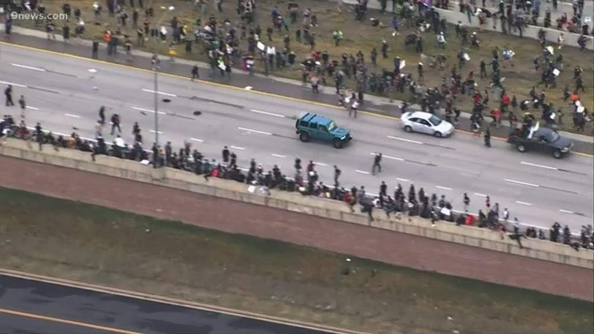 Aerial shot of jeep speeding through protest crowd. [Denver 7]