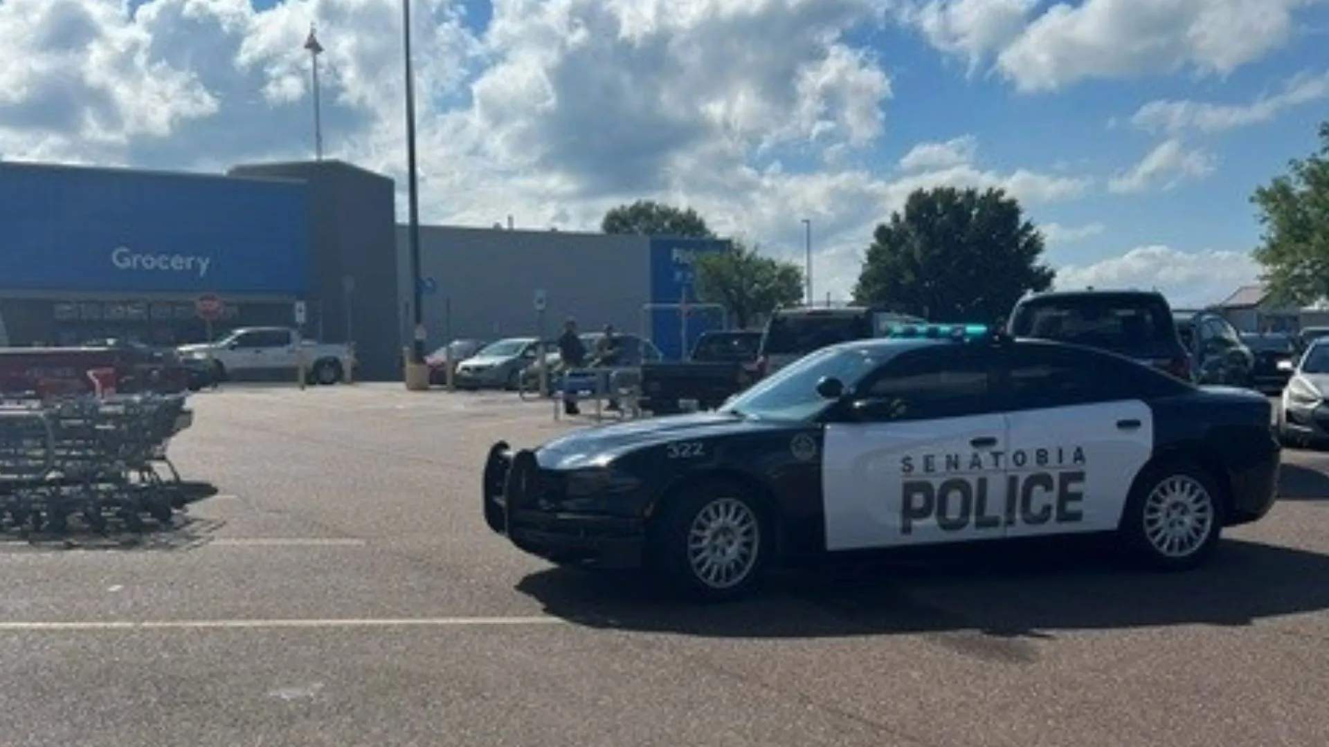 Crime scene tape and police vehicles in a Walmart parking lot in Senatobia, Mississippi after a police shooting.