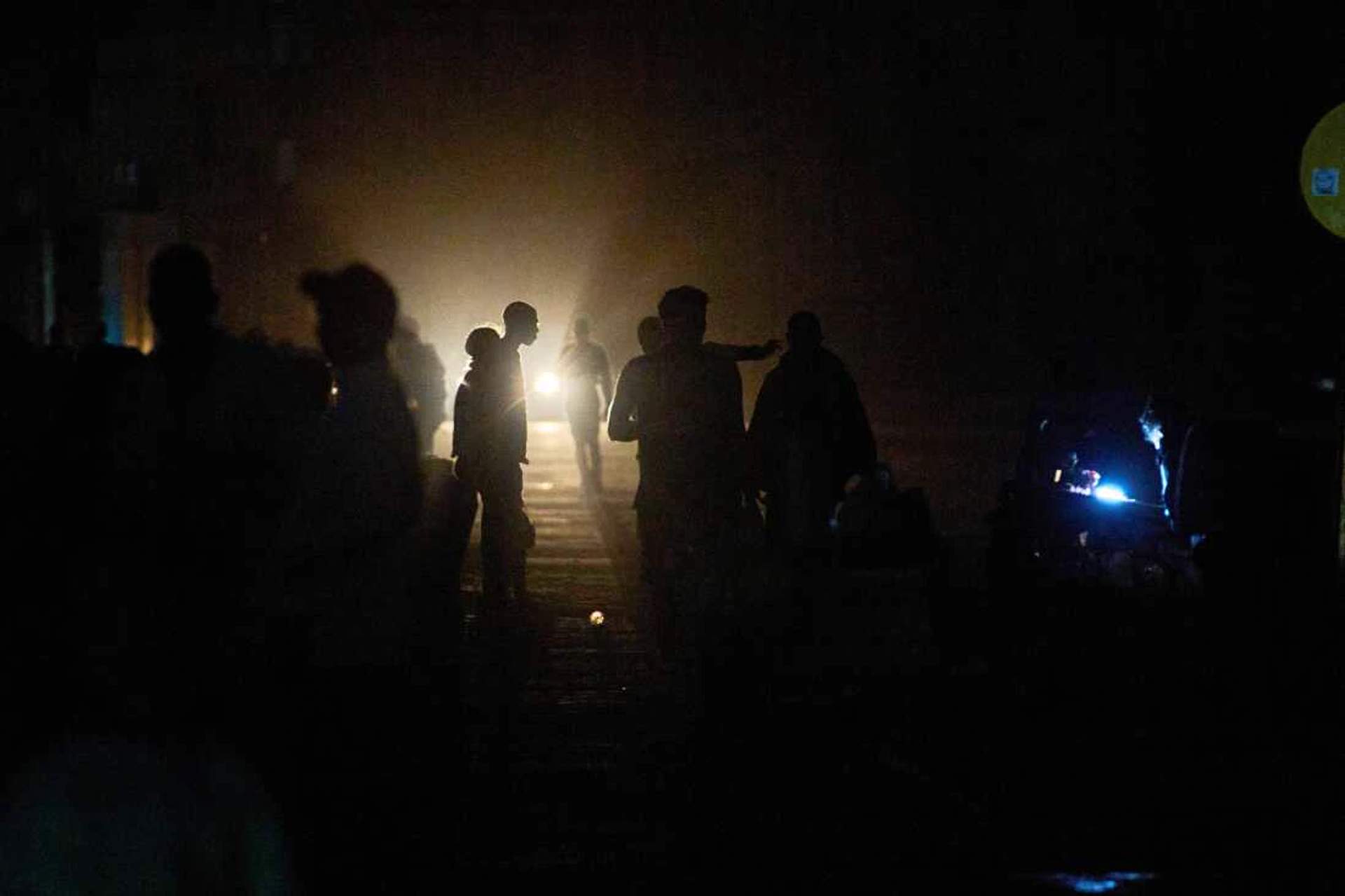 People walk in total darkness on a Havana street during a blackout