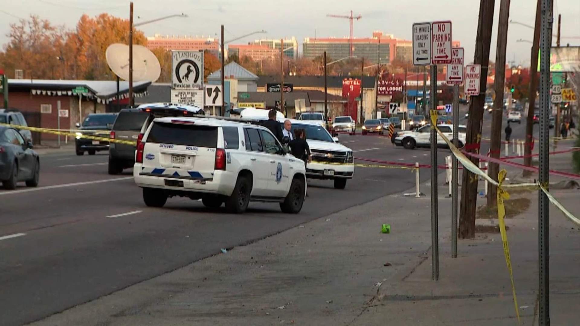 Police investigation at a shooting scene on a Denver street with evidence markers and emergency vehicles