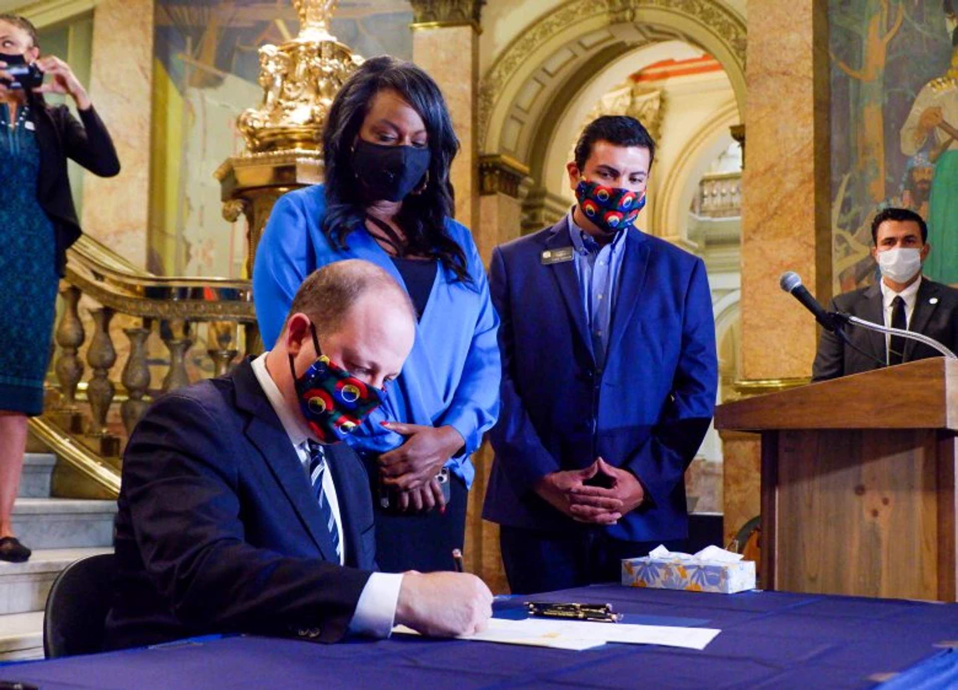 Colorado Governor Jared Polis signs the police accountability bill SB217 in 2020 with legislators and reform advocates