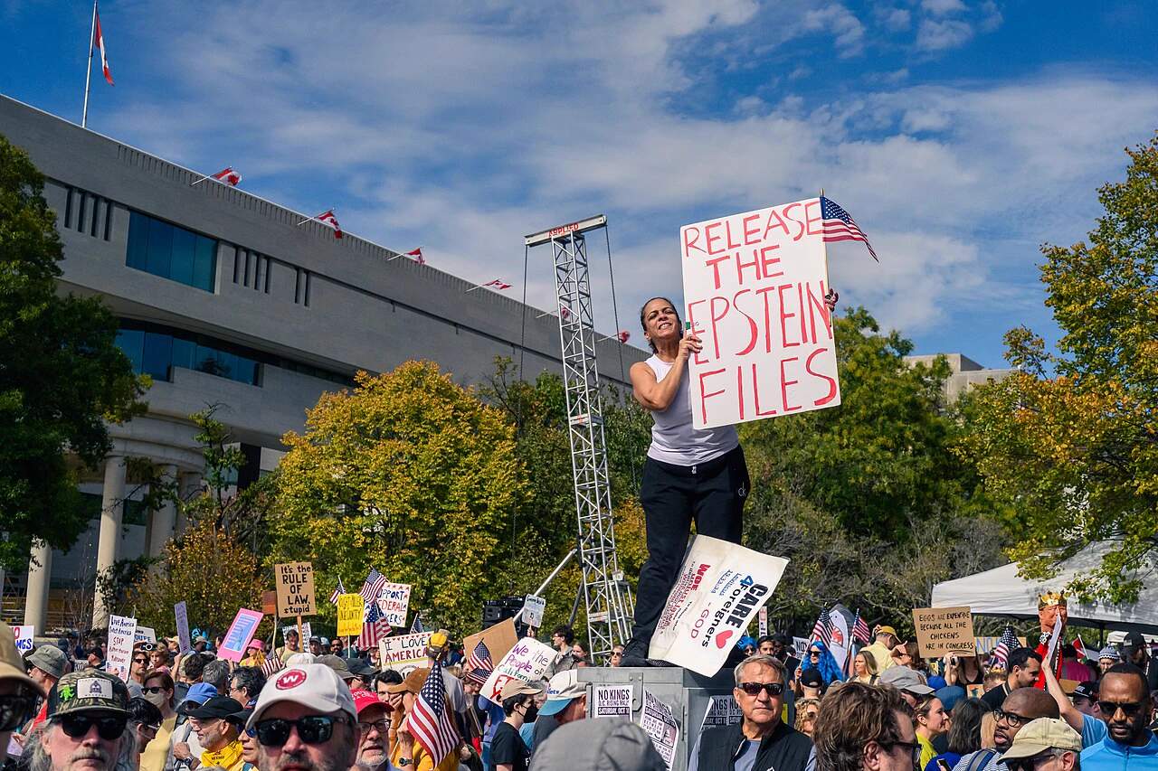 Protesters holding signs outside a government building demanding the release of the Epstein investigation files