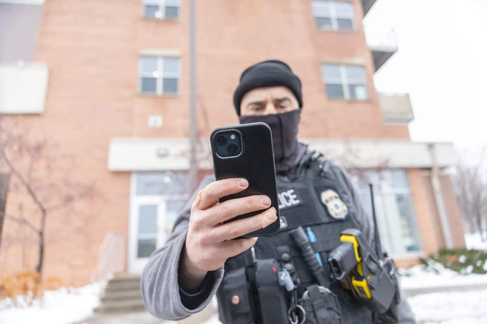 An immigration agent holds up his phone to a journalist in Minneapolis on Jan. 6, 2026. Credit: Chris Juhn