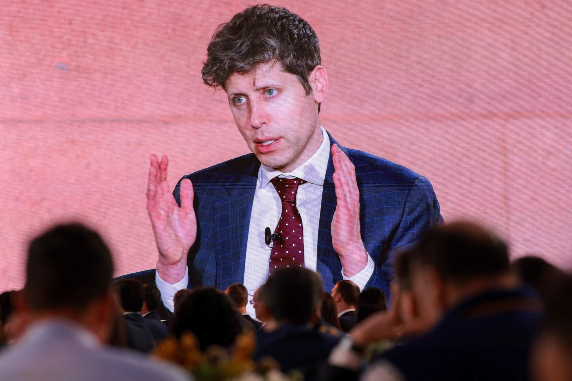A screen displays OpenAI CEO Sam Altman speaking during the 2026 Infrastructure Summit of government officials, corporate executives, and labor leaders, in Washington, March 11, 2026.