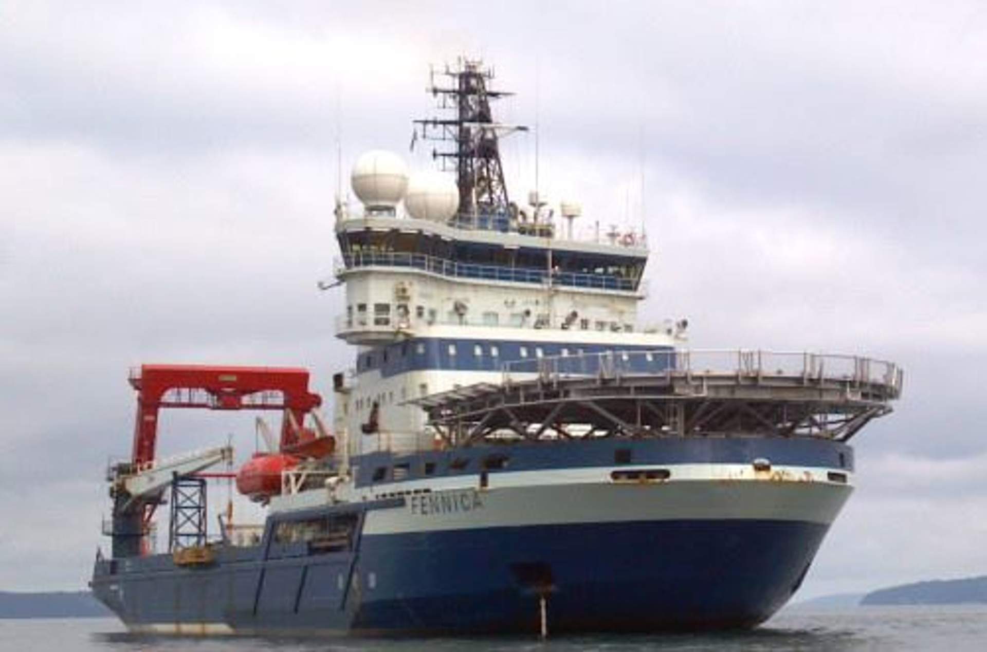 The Fennica, a blue-and-white icebreaker support vessel, in open water.