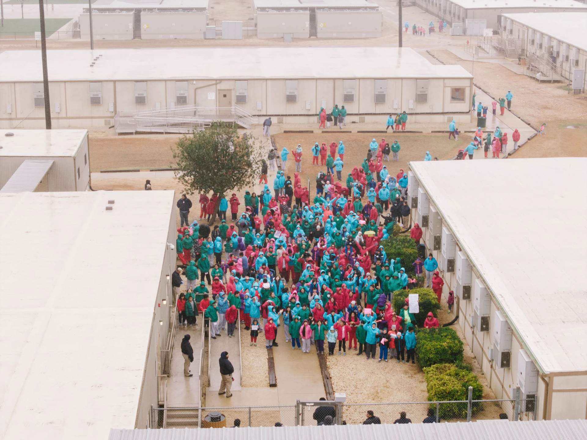 Families detained at the Dilley Immigration Processing Center in Texas wave signs during a demonstration on Saturday, Jan. 24, 2026.