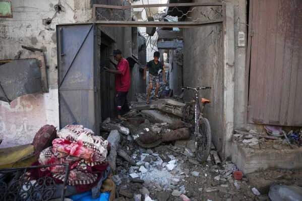 Palestinians inspect destroyed buildings at the scene of an Israeli airstrike in Nuseirat, central Gaza Strip, August 1, 2026