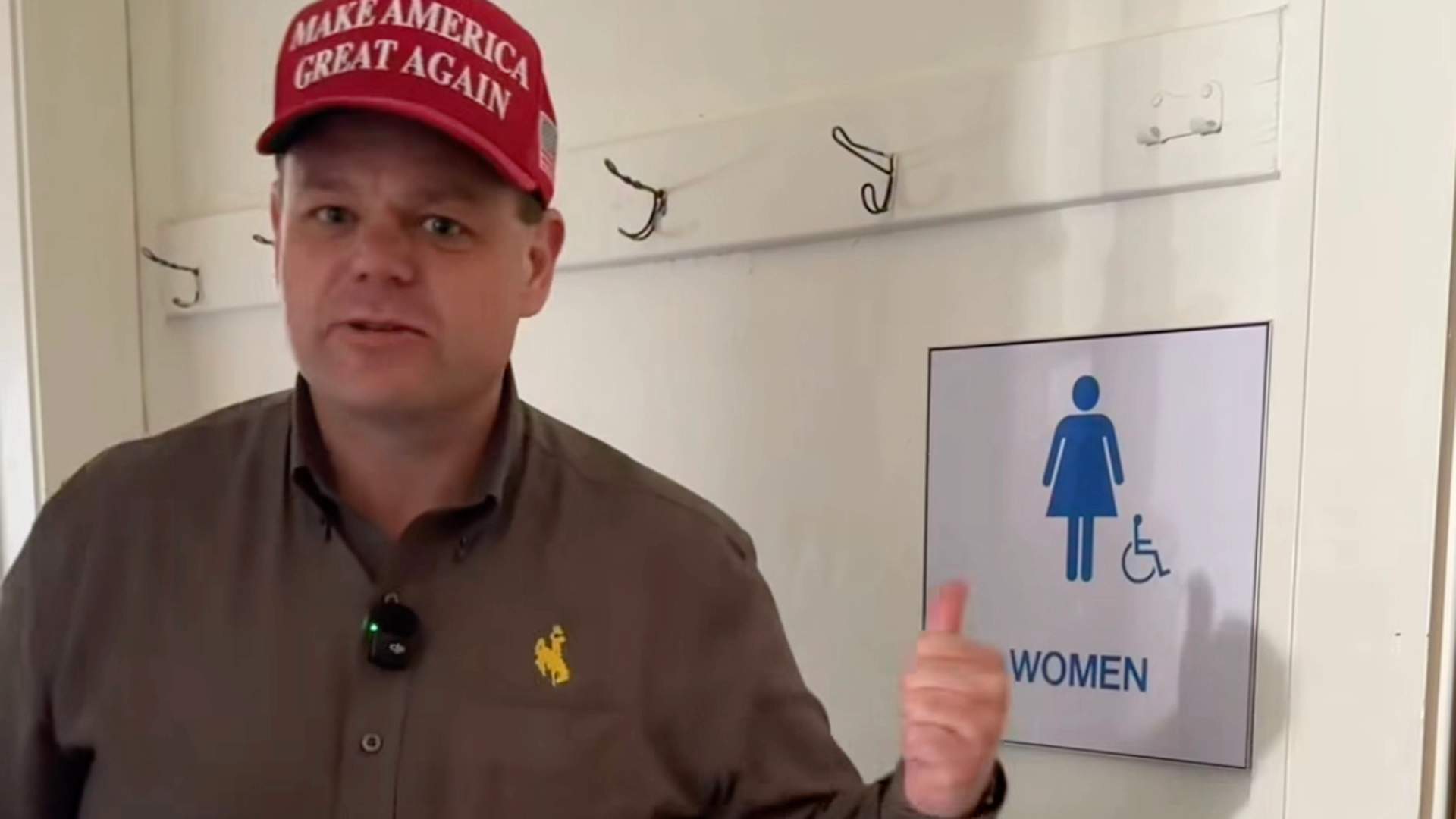 Screenshot from Reid Rasner's transphobic campaign video showing him kicking open bathroom stall doors