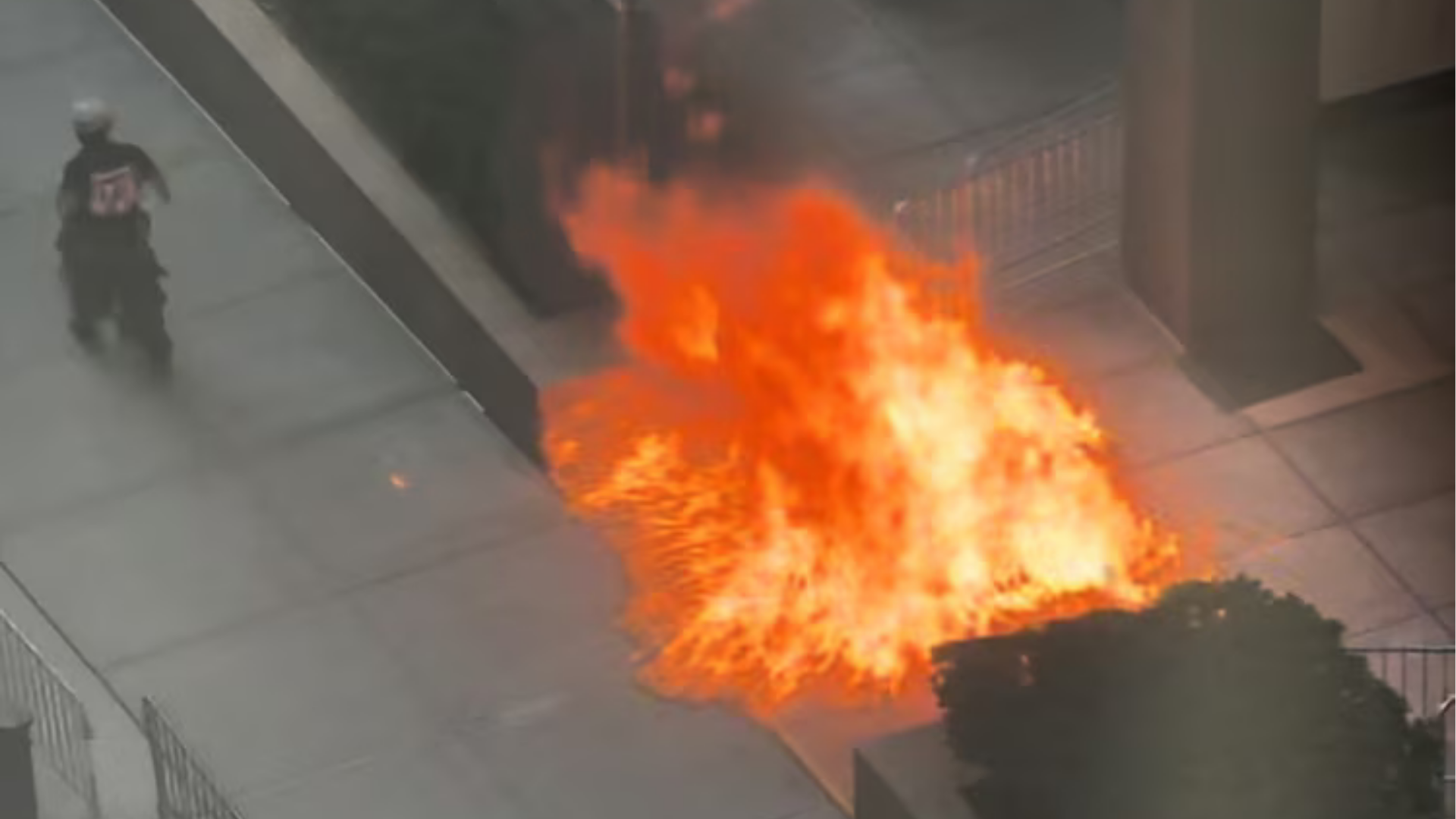 Shopping cart engulfed in flames outside of the federal building seen from above.
