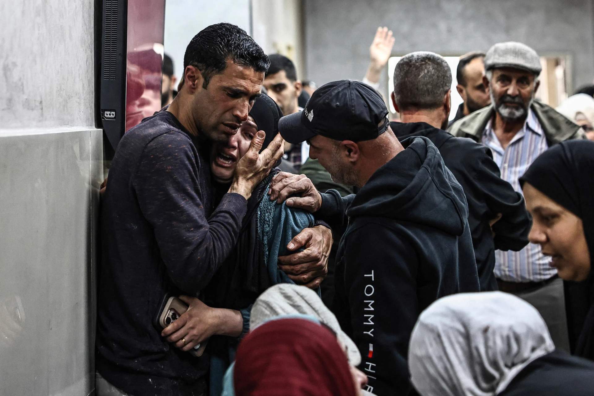 Palestinian relatives mourn over the bodies of two Palestinians killed during an Israeli settler attack on a West Bank school