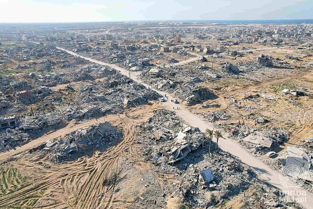 Aerial photograph showing vast destruction of buildings in Rafah, Gaza, with rubble-filled lots and damaged structures stretching to the horizon