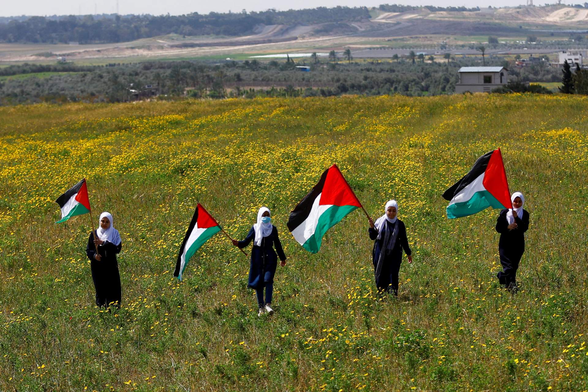 Palestinians wave Palestinian flags during a Land Day commemoration in the southeast of Gaza City, March 30, 2023