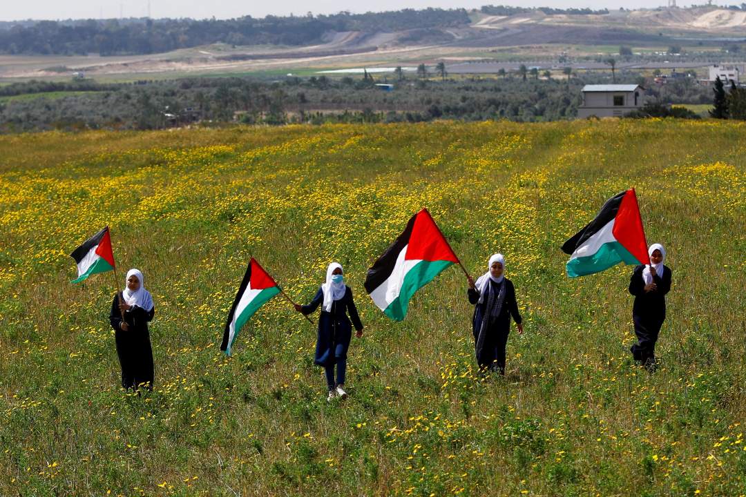 Palestinians wave Palestinian flags during a Land Day commemoration in the southeast of Gaza City, March 30, 2023