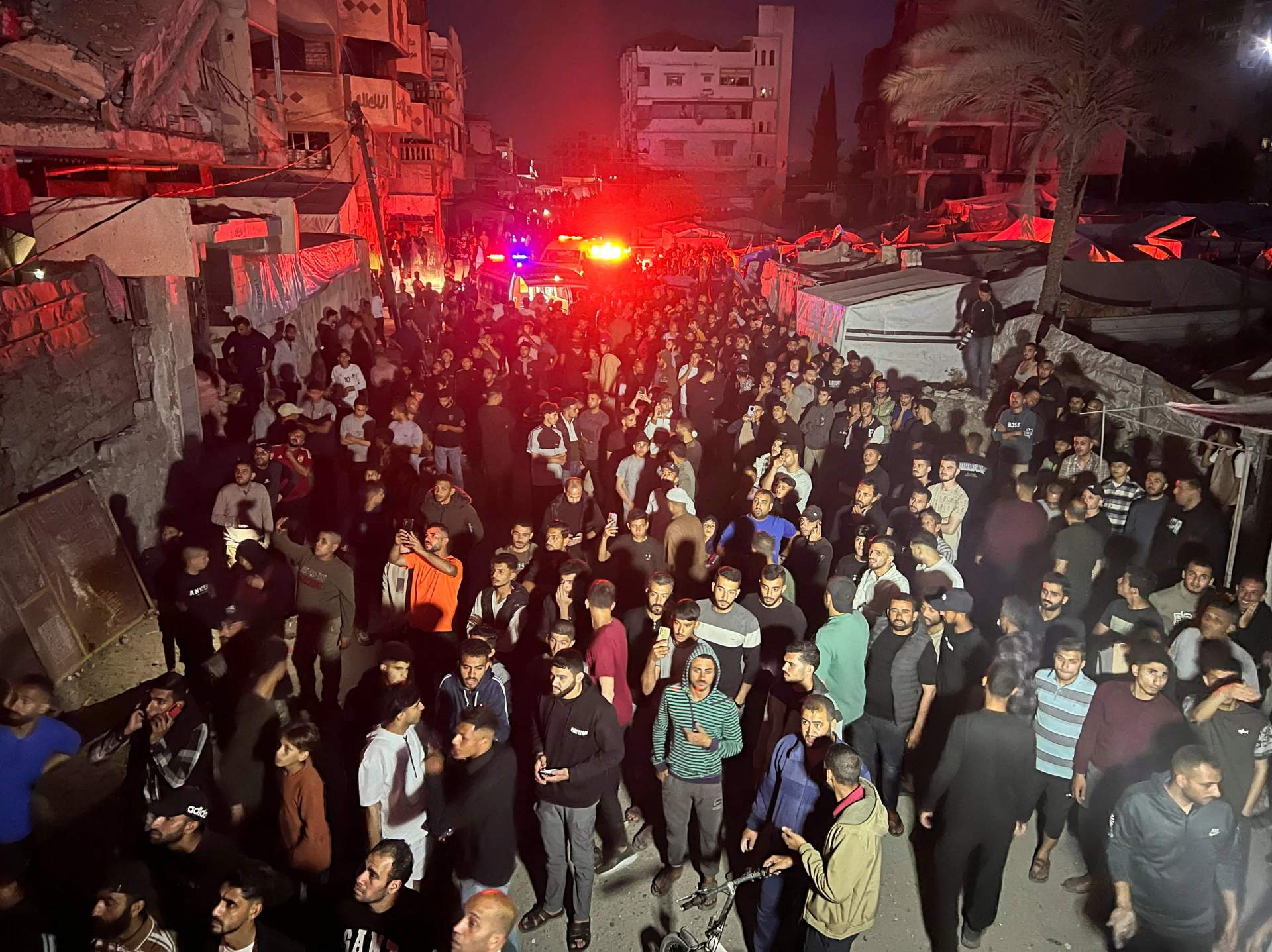 People gathered around a burning residential apartment building hit by an Israeli airstrike in Gaza City on Nakba Day