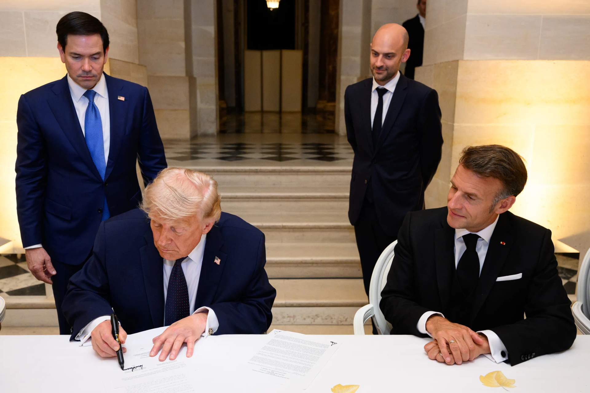 Trump signs the Islamabad Memorandum of Understanding at the Palace of Versailles on June 17, 2026, with French President Emmanuel Macron beside him