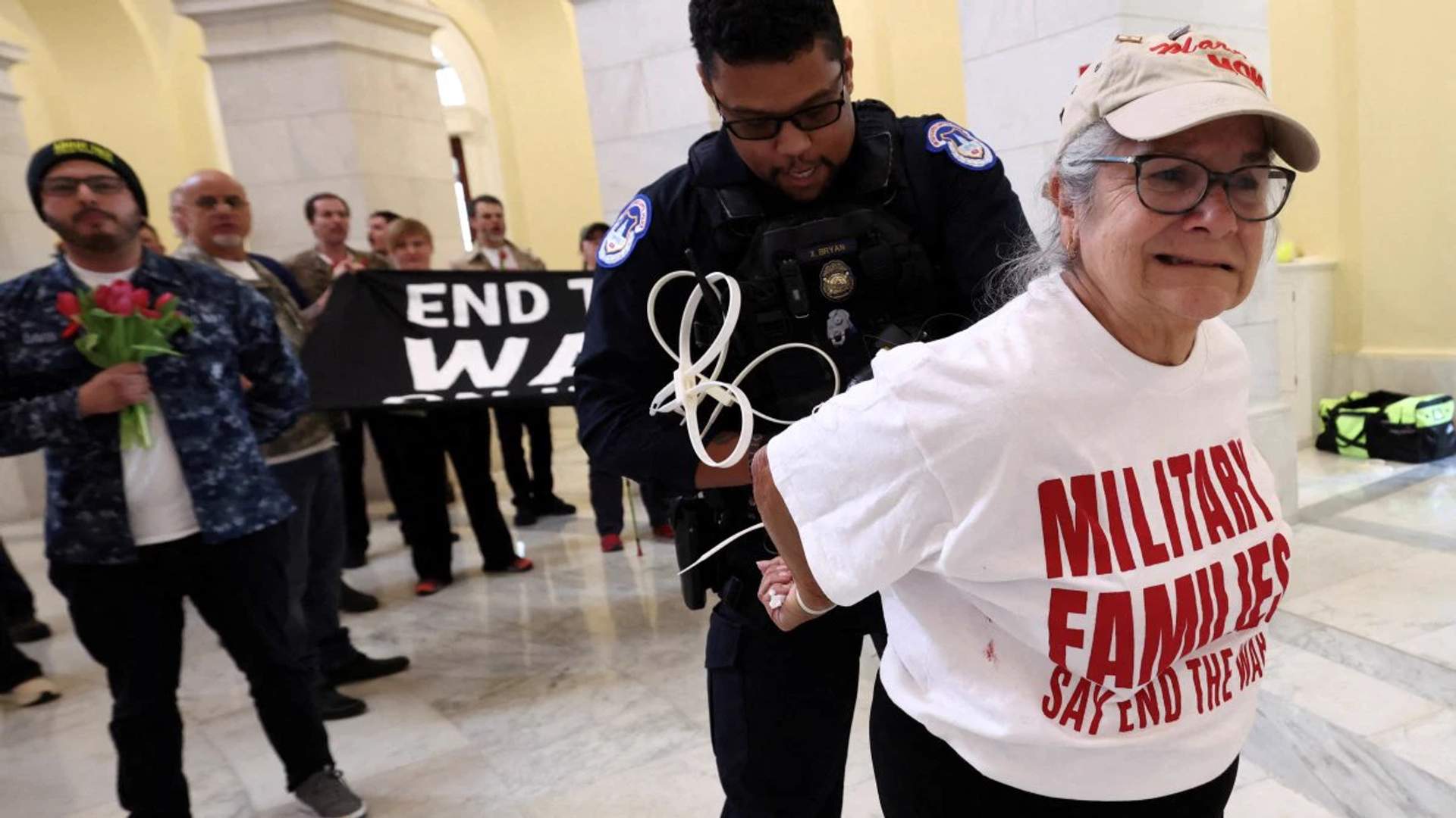 A protester's hands are zip-tied during a protest against the Iran war by veterans from the group About Face and members of military families in the Cannon House Office Building Rotunda on Capitol Hill.