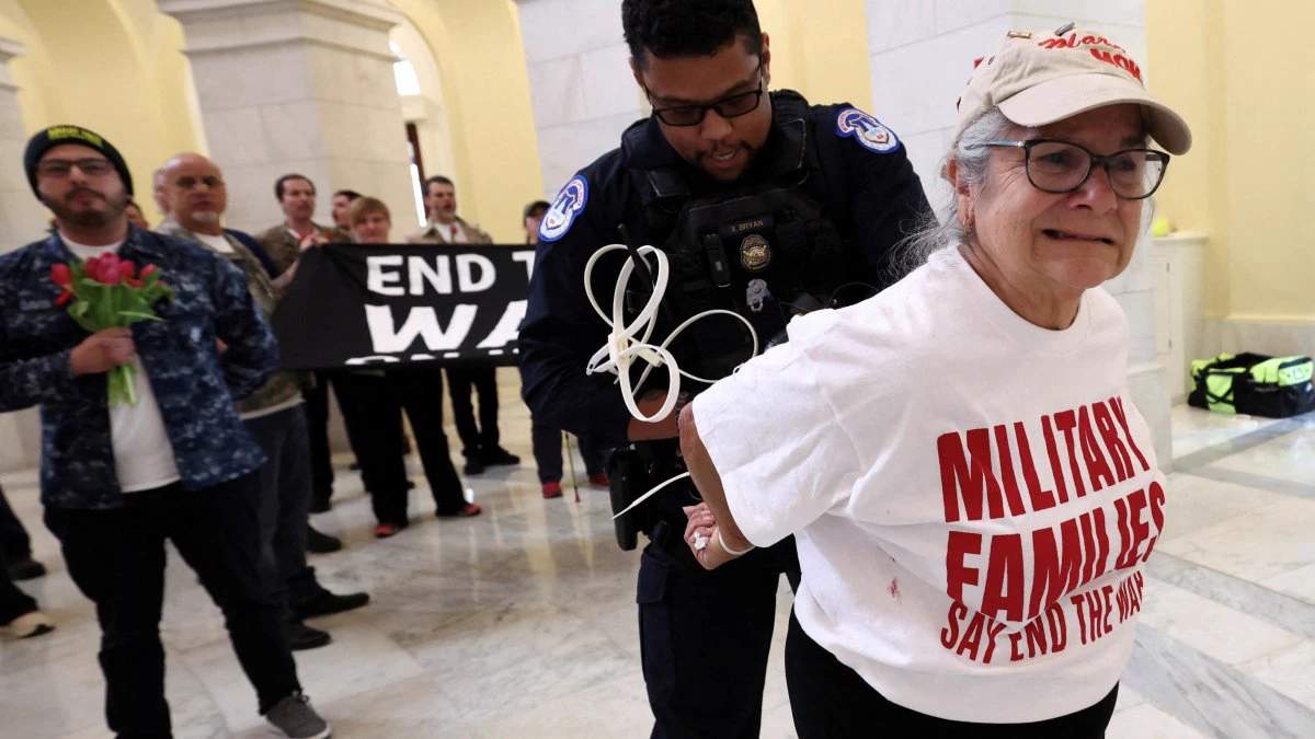 A protester's hands are zip-tied during a protest against the Iran war by veterans from the group About Face and members of military families in the Cannon House Office Building Rotunda on Capitol Hill.