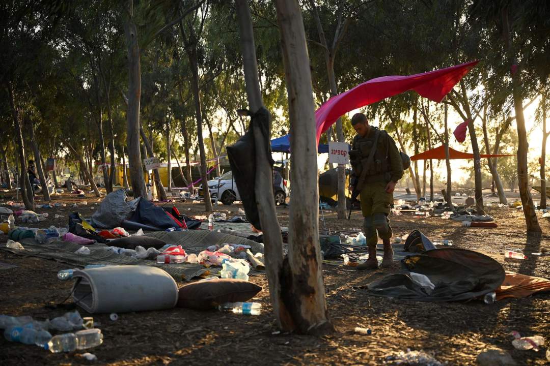 Wide shot of abandoned cars scattered across a dusty field with personal belongings and debris at the Nova music festival site near Re'im, Israel