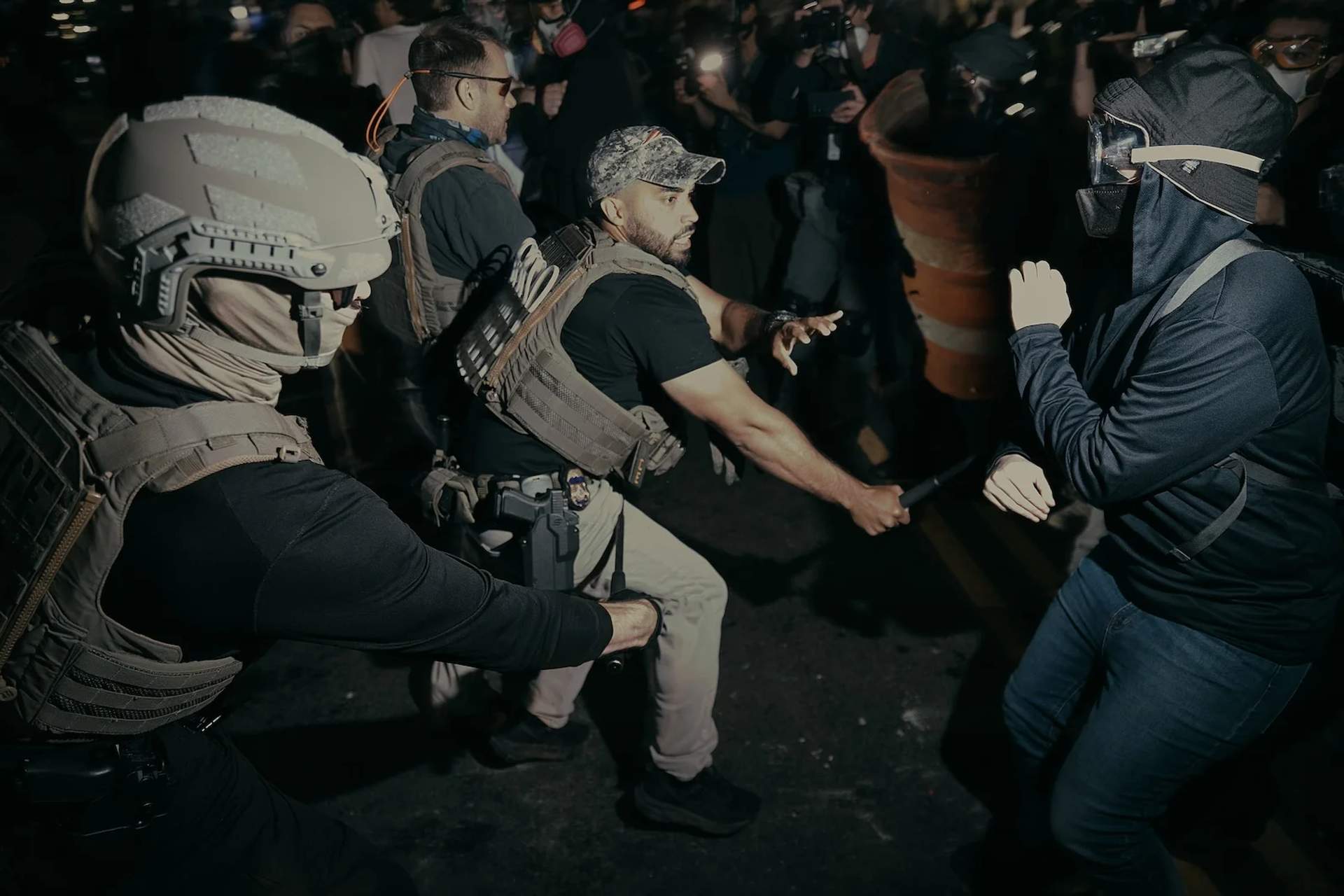 ICE agents with batons clash with protesters during nighttime demonstrations at Delaney Hall