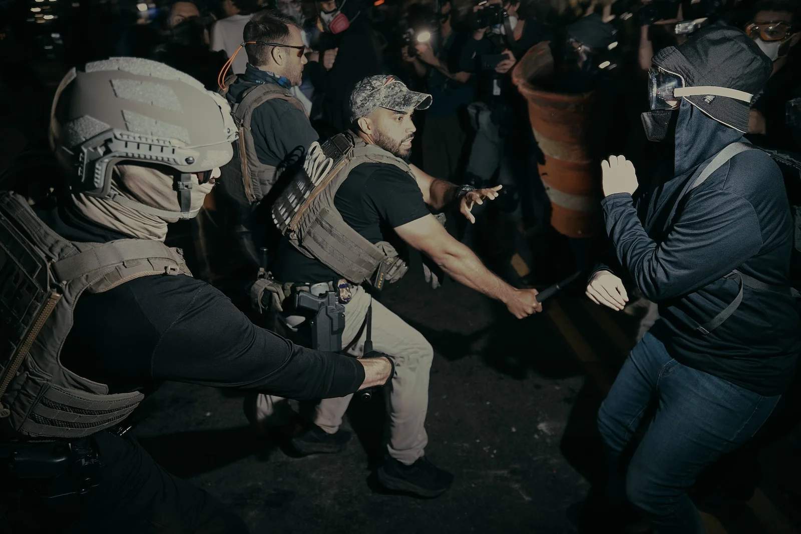ICE agents with batons clash with protesters during nighttime demonstrations at Delaney Hall